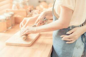 woman's hand is thresh flour to making the pasta on the wood table, in concept of Italian food. threshing flour for making bread bakery in cozy kitchen at home. photo