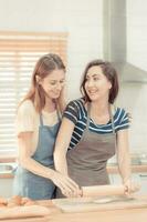 Two caucasian women cooking pizza together in the kitchen. The concept of home cooked food and LGBT relationships. family and diversity concept. lgbt love. warm tone photo