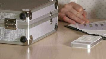 Young lady making some calculation at office table. Closeup video