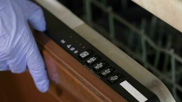 Door of dishwashing machine with function buttons. Closeup video