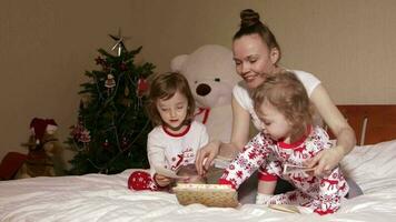 Young mother shows wooden box with old photos to her small children video