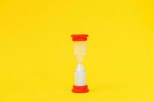 Hourglass from a board game on a yellow background photo