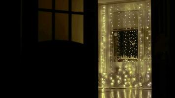 Noël ornements et lumière réfléchi sur le fenêtre à nuit derrière transparent rideau video