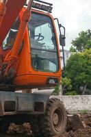 Orange hydraulic excavator at a construction site photo