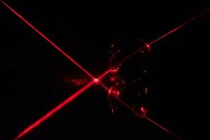Red laser beam reflecting on a mirror photo