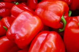 apilar de rojo campana pimientos en un mercado puesto foto