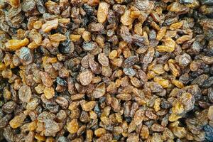 Stack of organic dried black raisins on a market stall photo