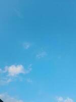 White clouds in the blue sky. Beautiful bright blue background. Light cloudy, good weather. Curly clouds on a sunny day. photo