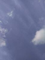 White clouds in the blue sky. Beautiful bright blue background. Light cloudy, good weather. Curly clouds on a sunny day. photo