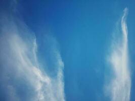 Beautiful white clouds on deep blue sky background. Large bright soft fluffy clouds are cover the entire blue sky. photo