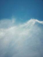 hermosas nubes blancas sobre fondo de cielo azul profundo. grandes nubes esponjosas suaves y brillantes cubren todo el cielo azul. foto