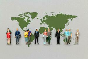 Miniature people standing on the world map with gray background photo