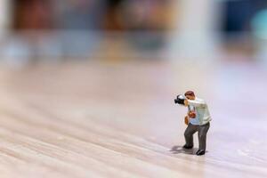 Miniature people Photography holding a camera and copy space for text photo