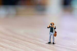 Miniature people Photography holding a camera and copy space for text photo