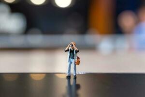 Miniature people Photography holding a camera and copy space for text photo