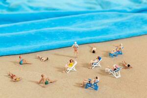 A tiny person in a swimsuit is relaxing on the beach in the summer photo