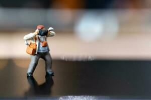 Miniature people Photography holding a camera and copy space for text photo