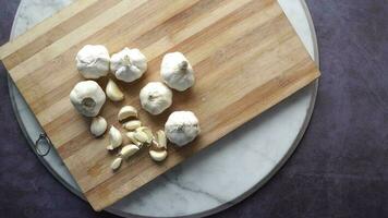 Close up pf garlic on a chopping board against black background video