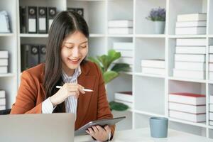 Asian businesswoman smiling confidently successful entrepreneur elegant professional company executive wearing a suit standing in the office with arms crossed. photo