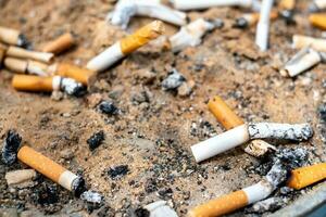 Cigarette butts on a gray background photo