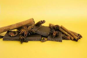 Milk chocolate and cinnamon sticks close-up. Photos in warm colors. Sweetness. World chocolate day. Macro.