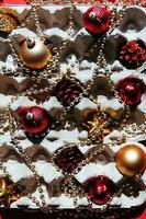 Christmas tree toys in the egg tray on a red background. Top view. The concept of New Year's holidays and Christmas. Red and gold colors. photo