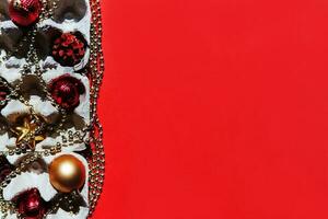 Christmas tree toys in the egg tray on a red background. Top view. The concept of New Year's holidays and Christmas. Red and gold colors. photo