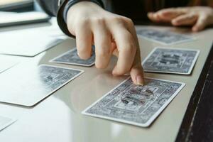 TVER, RUSSIA - FEBRUARY 11, 2023. Tarot cards, Tarot card divination, esoteric background. A woman makes a layout on the cards at the table. Divination, predictions on tarot cards. photo