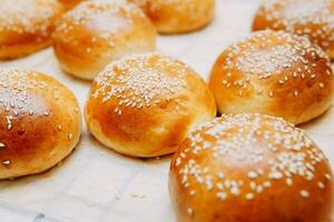 Freshly baked burger buns with sesame seeds. We cook at home. photo