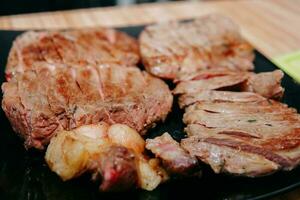 Beef steak with greens on a black plate. Steak with Basil cooked in the culinary master class photo