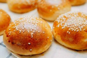 Freshly baked burger buns with sesame seeds. We cook at home. photo