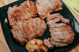 carne de vaca filete con verduras en un negro lámina. filete con albahaca cocido en el culinario Maestro clase foto