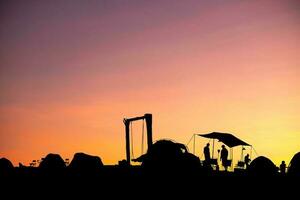 Silhouette of camping tent of tourists on blurred twilight light orange background, photo