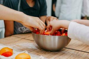 preparando un postre a un Cocinando Maestro clase. cestas con duraznos y fresas, hogar cocinando. de cerca, selectivo enfocar. pasteles, pasteles con duraznos desde soplo Pastelería. foto