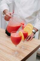 cooking strawberry smoothies at a culinary master class, pouring smoothies into glasses photo