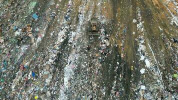 Expansive view of the bulldozer and egret birds at landfill site. Aerial view video