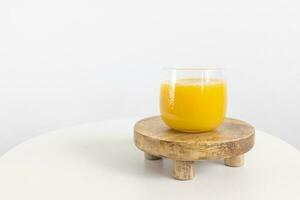 Fresco exprimido naranja jugo en vaso en mesa en blanco antecedentes. sano bebida para desayuno foto
