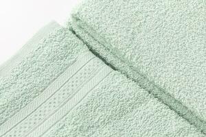 Folded mint green bath sheet or towels on white background. Close-up of texture, copy space photo