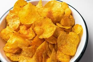 Smoked paprika potato chips in bowl, closeup photo