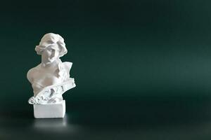 Marble head of young woman, ancient Greek goddess bust isolated on green background with space for text. photo