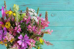 Wild field flowers bouquet, on wooden background, copy space photo