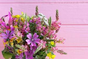 Wild field flowers bouquet, on wooden background, copy space photo