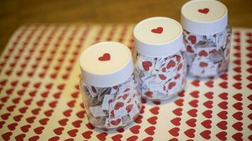 Hearts in jars. Stickers made at home. Lot of red hearts in glass jars. White caps. photo