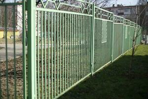 Green metal fence. Fence around area. Metal profile. photo