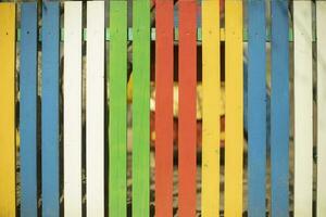 Colored fence made of wood. Boards of different colors. Cheerful hedge. Yard Details. photo