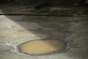 Puddle in sun. Dirty water. Puddle in road. photo