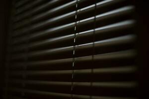 Blinds in dark room. Closed window. Closed blinds. photo