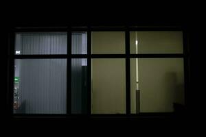 Window in building at night. Window in house. Light from office. photo