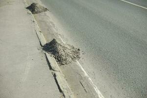 Dirt on road. Pile of garbage on side of road. Highway cleaning. photo