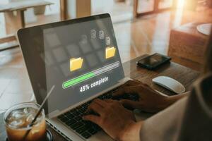 Transfer files data system relocation concept, Person hand using laptop computer waiting for transfer file process with loading bar icon on virtual screen. photo
